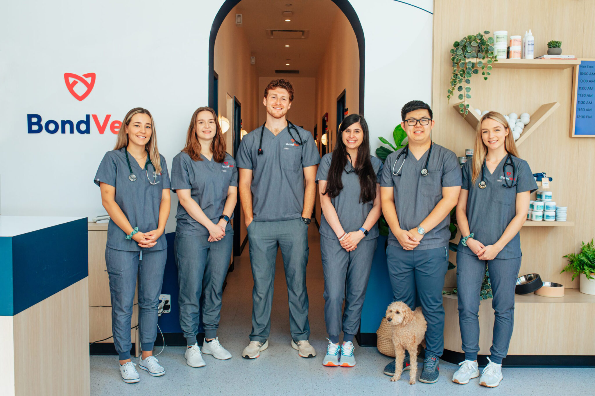 Six Bond Vet Veterinary staff members, in blue scrubs, smiling at the camera